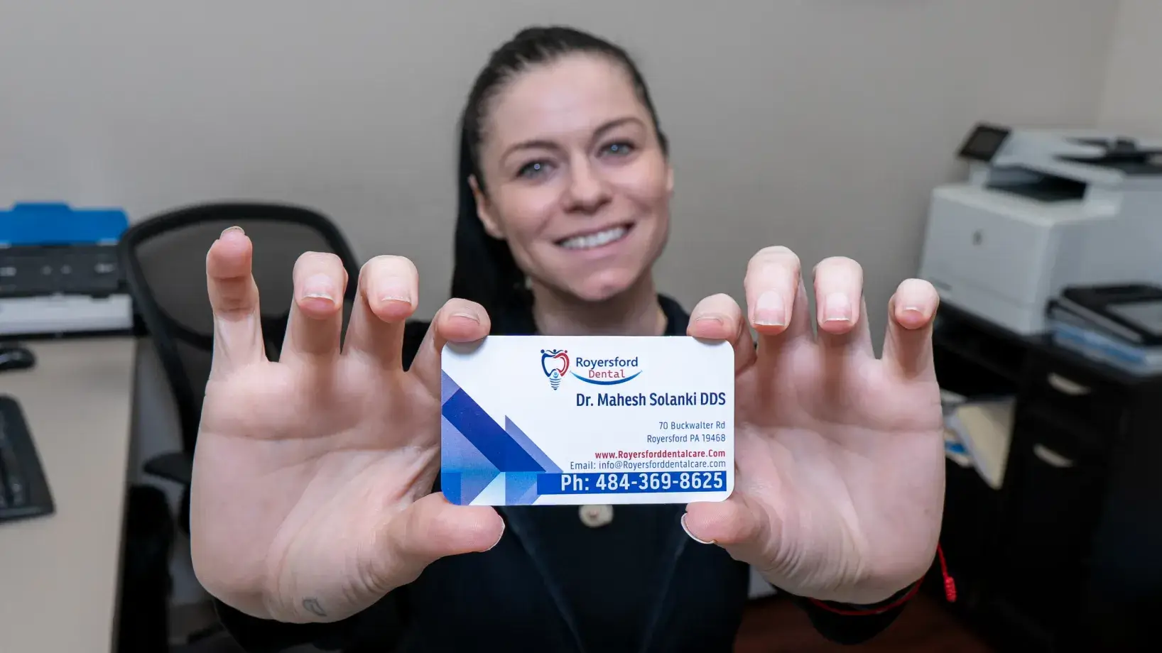 Royersford Dental team member holding a business card