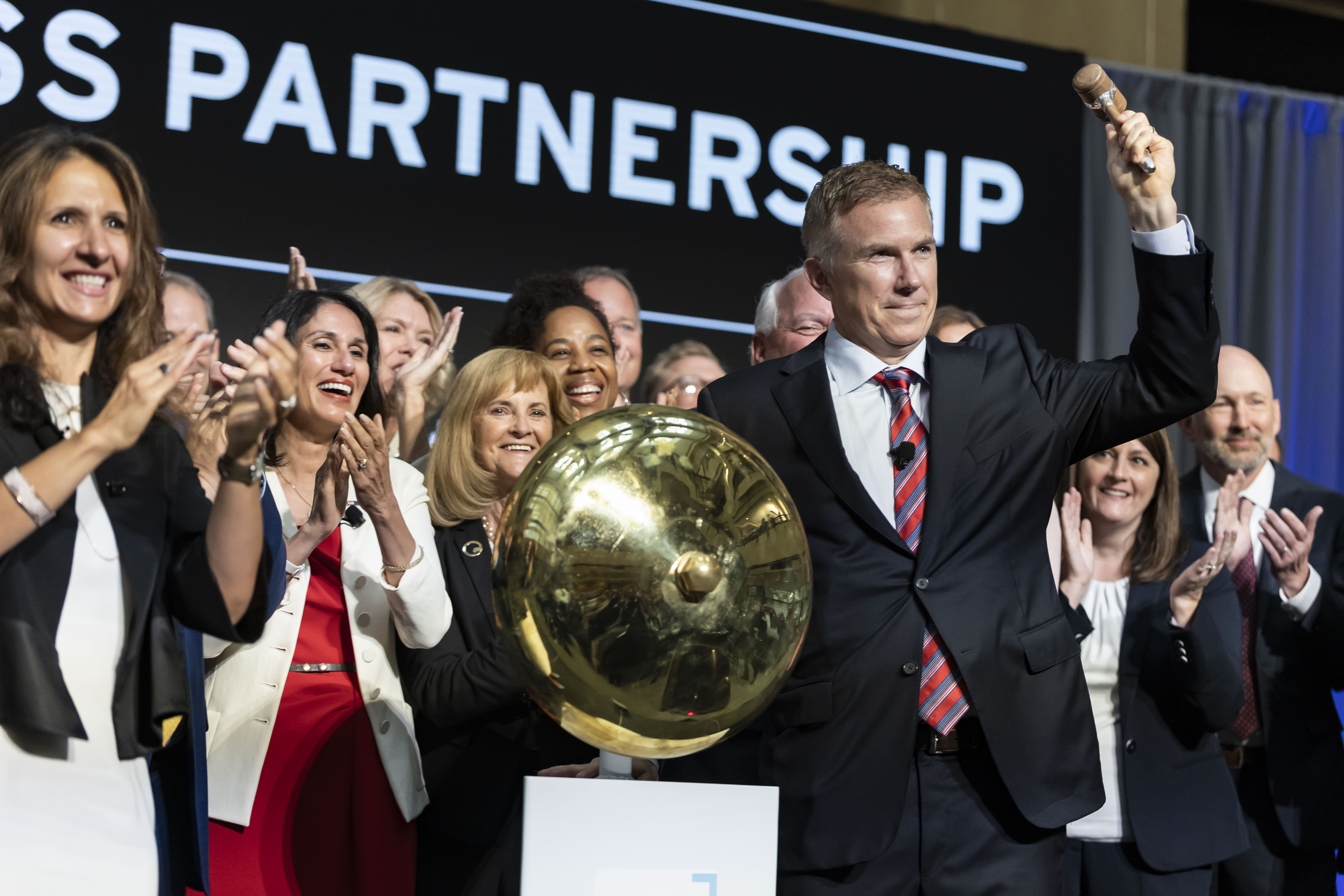 A group of CEOs crowd around the NYSE bellring in Minneapolis