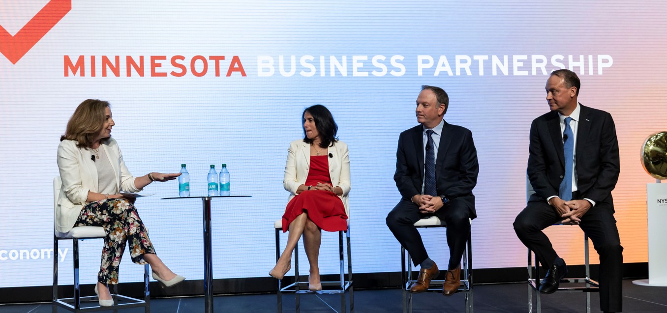Three CEOs sit on a panel with a host.
