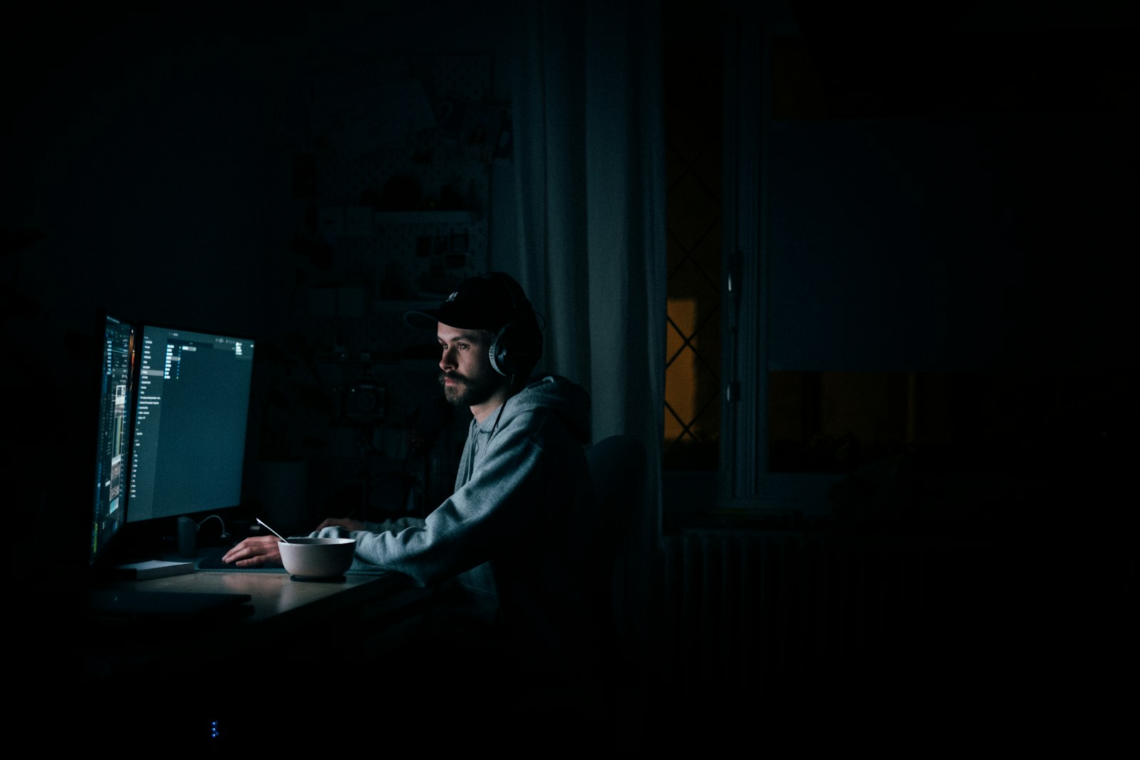 Person in hoodie working alone at a computer, representing accidental ownership of automated processes