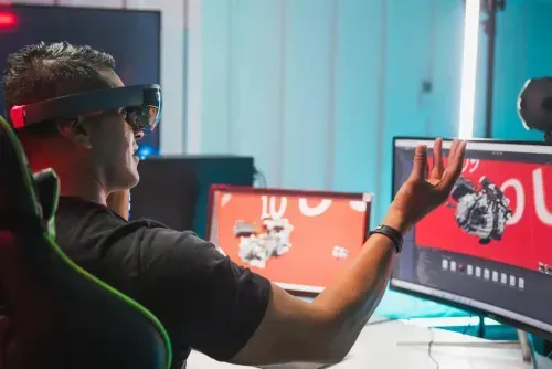 a man wearing a virtual reality headset in front of a computer screen