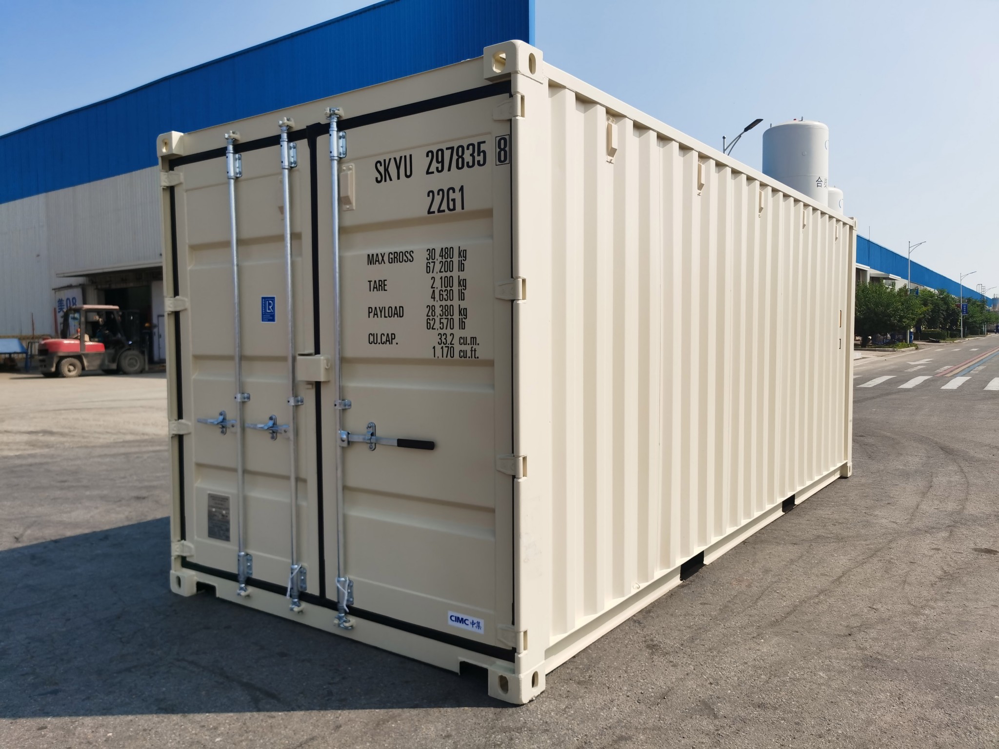 A creamy yellow shipping container in a large yard full of containers