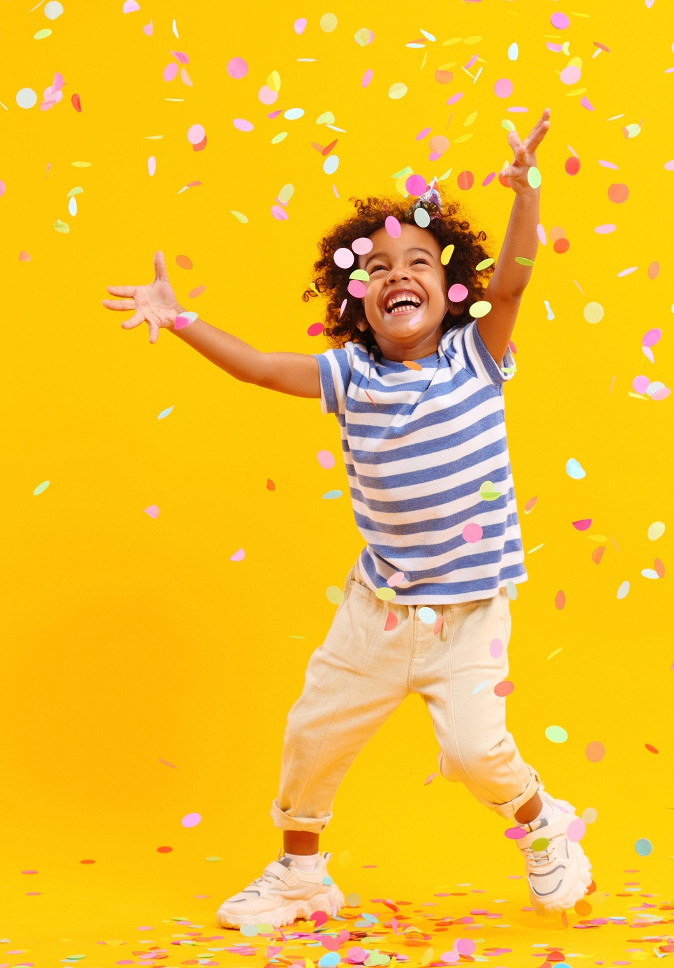 Happy girl playing with confetti
