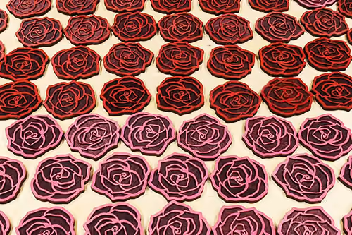 many rose-shaped coasters on a surface, created by Hexagon Laser