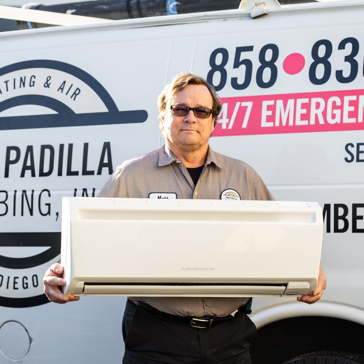 hvac technician holding an air conditioner