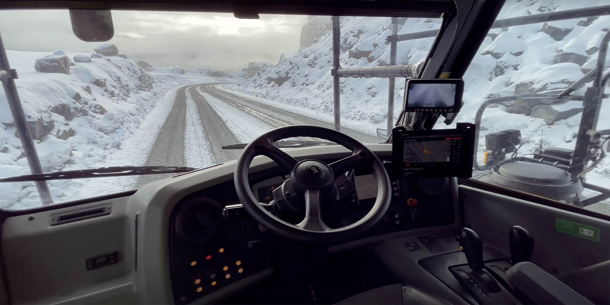 Autonomous dump truck with Steer technology on board, driving through a snowy terrain.