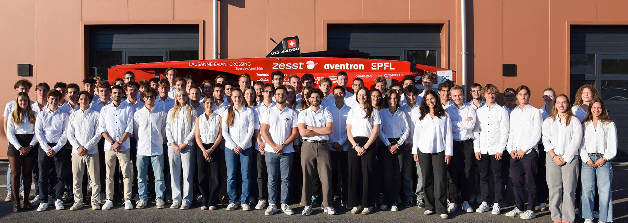 Team picture of «Swiss Solar Boat», students from EPFL, the foiler boat in the back