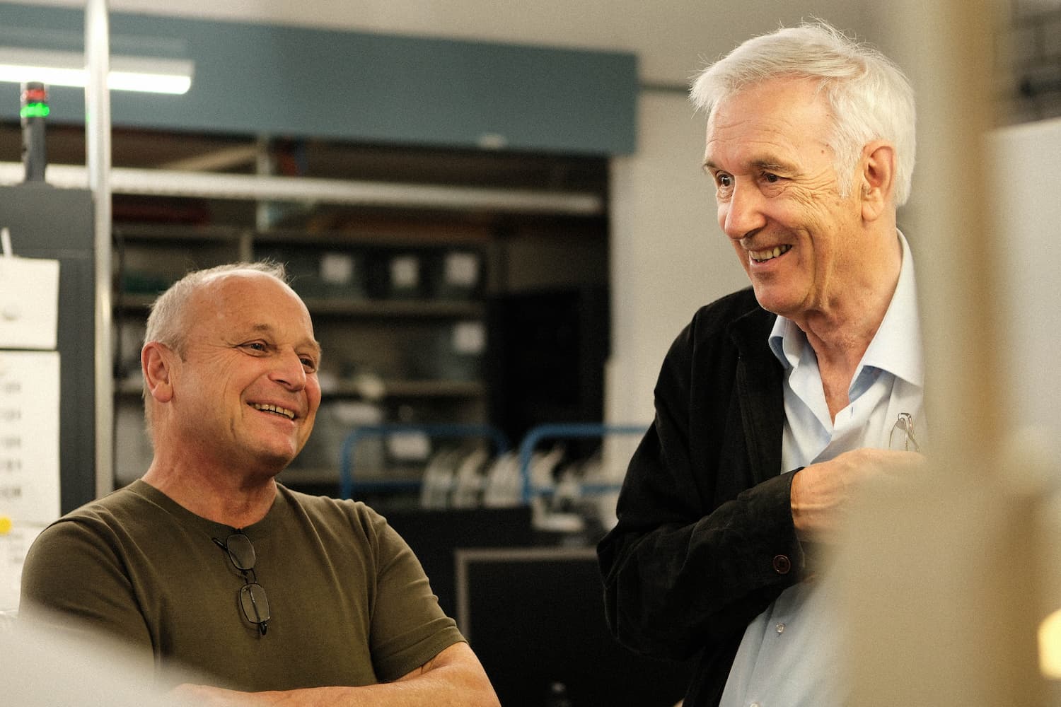 Tow company founders looking at old photos Many pictures on a table.