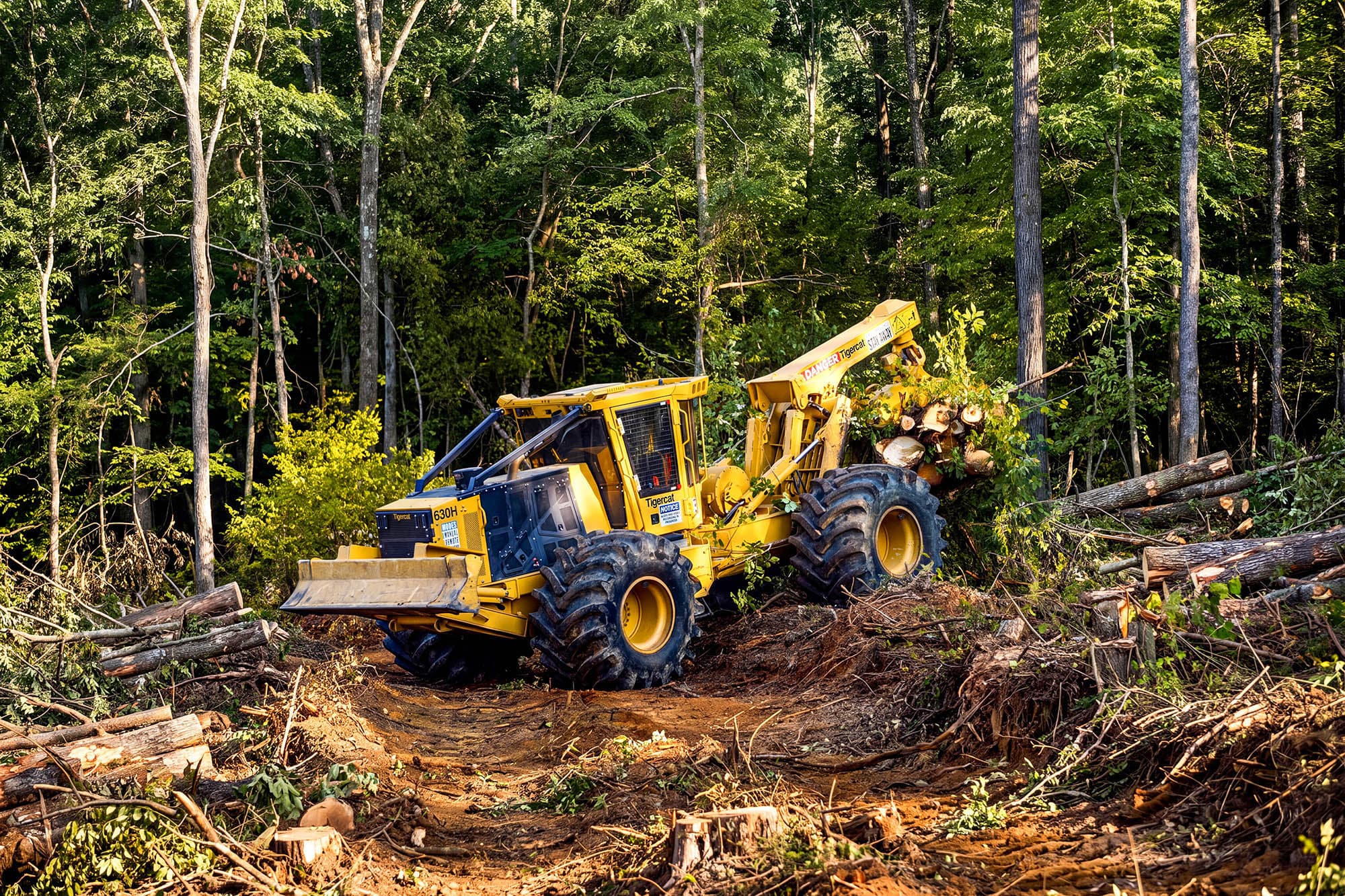 Autonomous Tigercat skidder equipped with Kodama's AI-powered technology transporting logs through rugged forest terrain