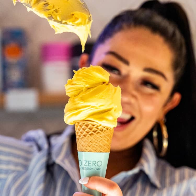 Happy shop worker filling an ice-cream cone