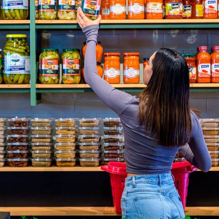 A shopper inspecting products on the shelves of Cedar Bakery