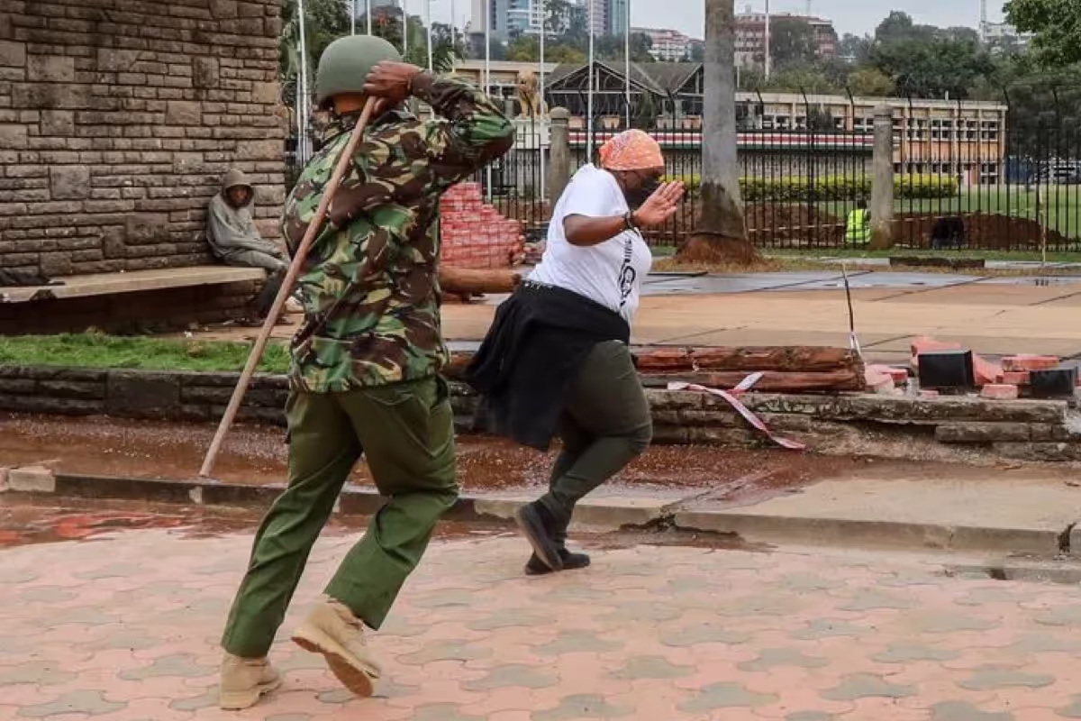 A Kenyan activist tries to guard herself against being beaten by police officers during a protest in Nairobi, 7 July 2021 (Photo: Daniel Irungu/EPA-EFE/Shutterstock.com)