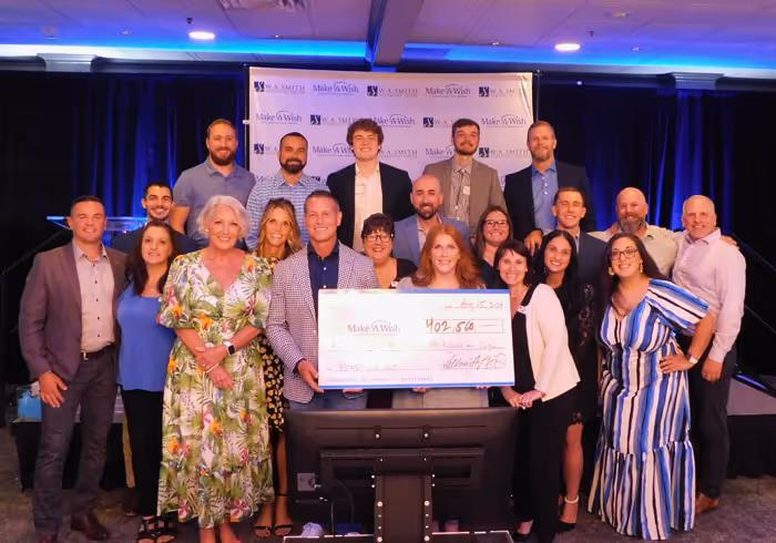 w a smith financial group team presenting check at 2024 make a wish event