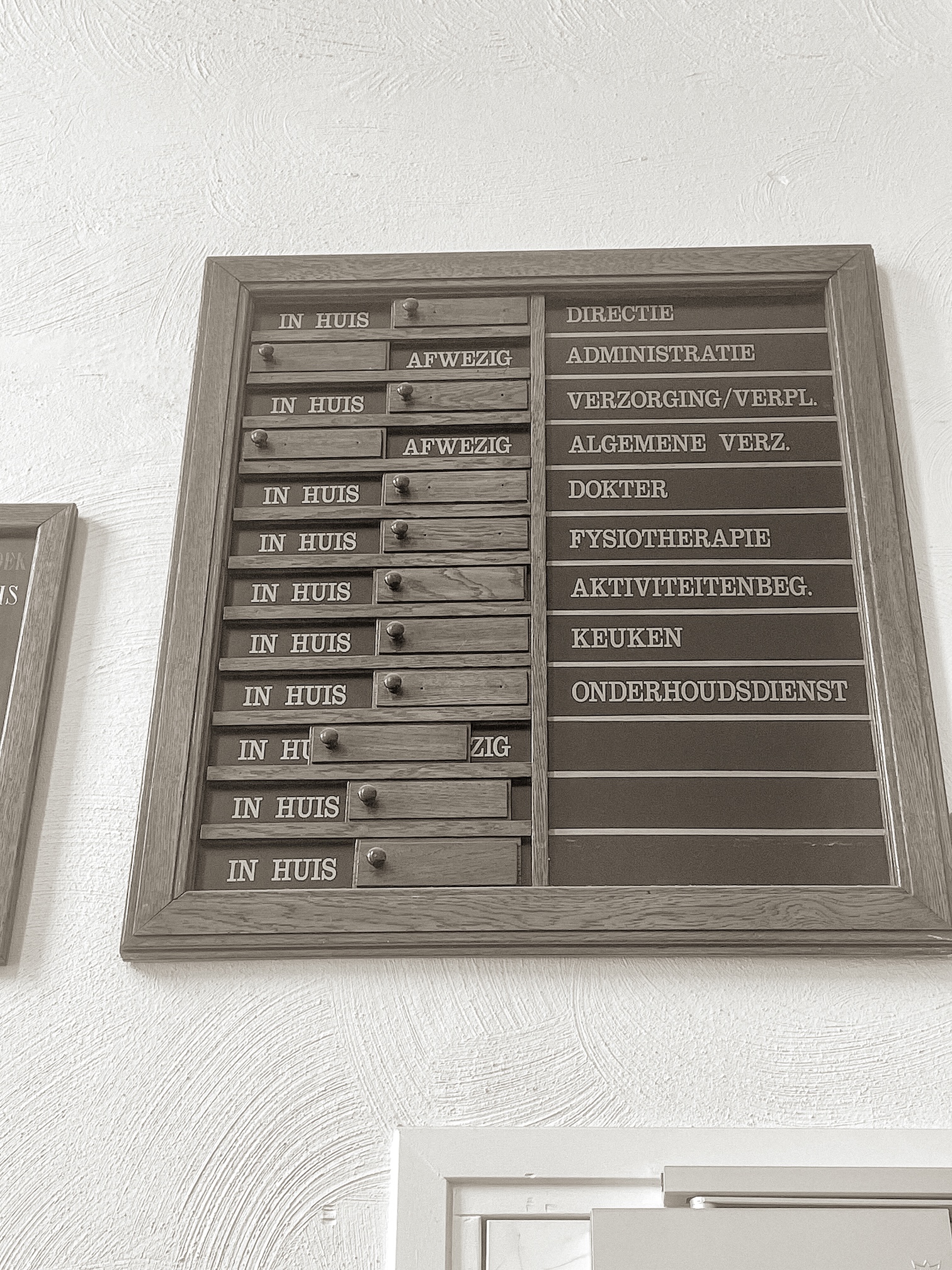 Een aanwezigheidsbord met afdelingen en functies in een zorginstelling