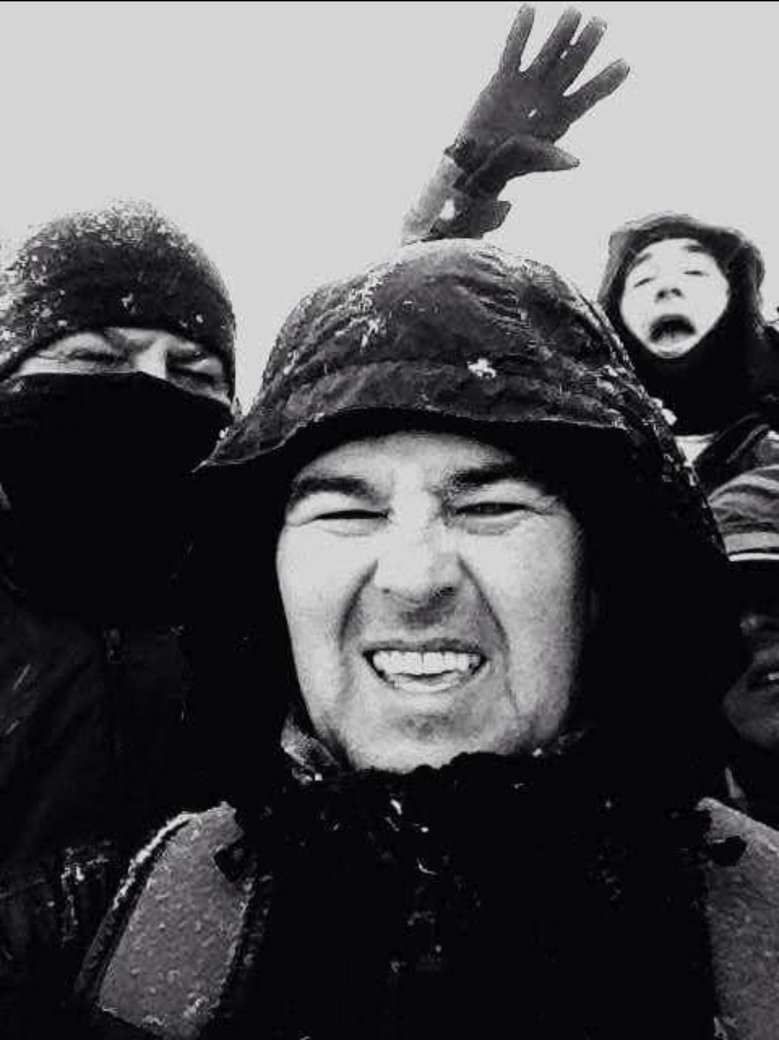 A selfie by Gareth Davies hiking in Eryri with two friends in the background, all well wrapped up against the snow