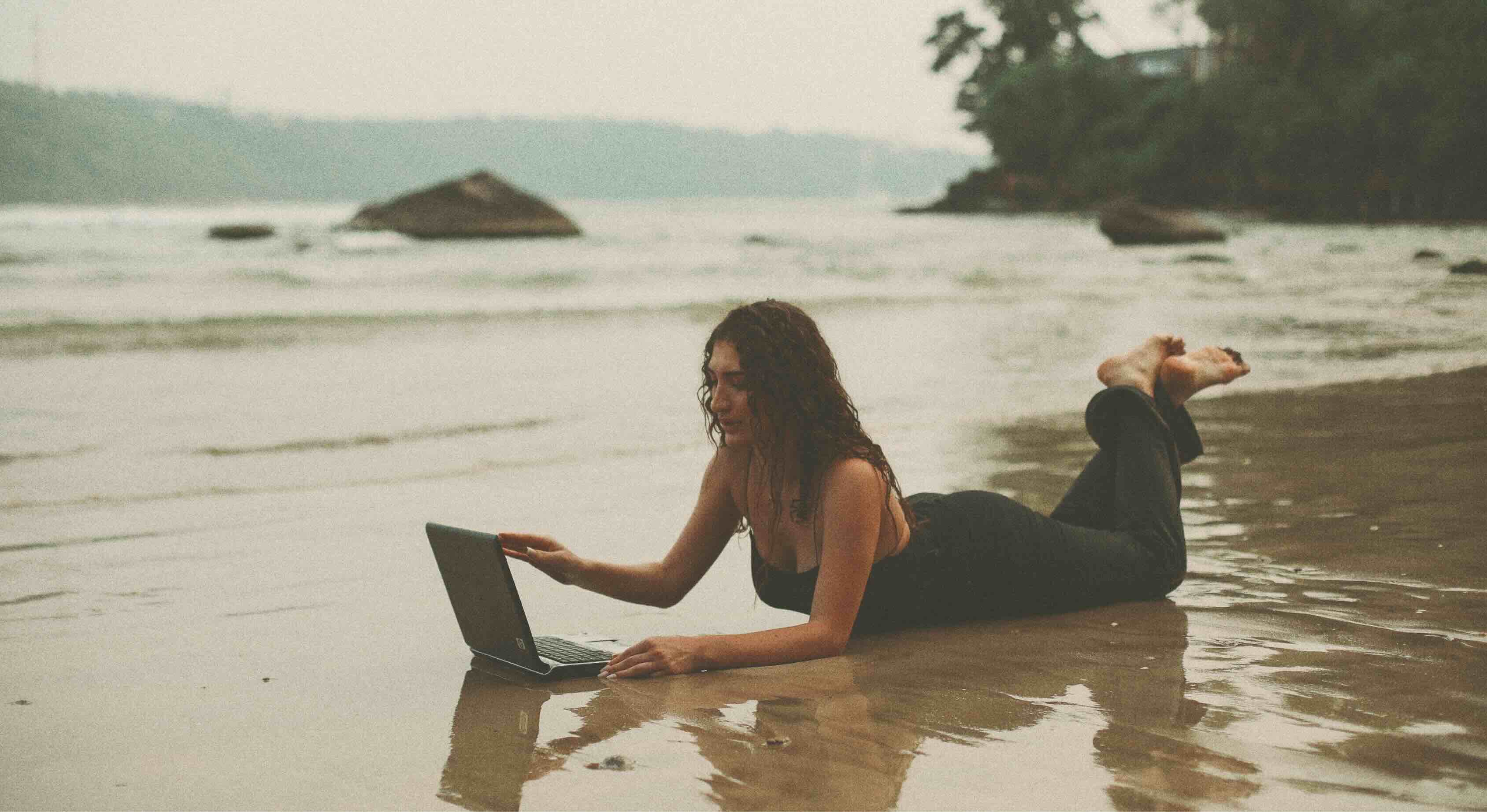 Frau mit Laptop am Strand