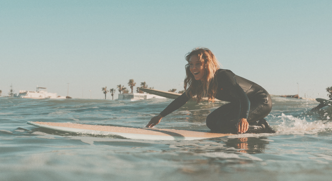 girl surfing with wetsuit in South of Spain