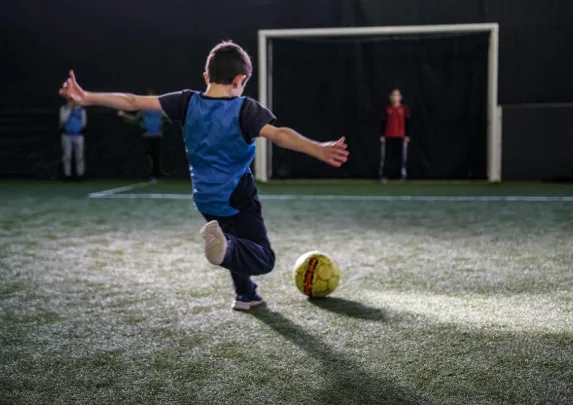 Foot en salle enfant qui tire au but