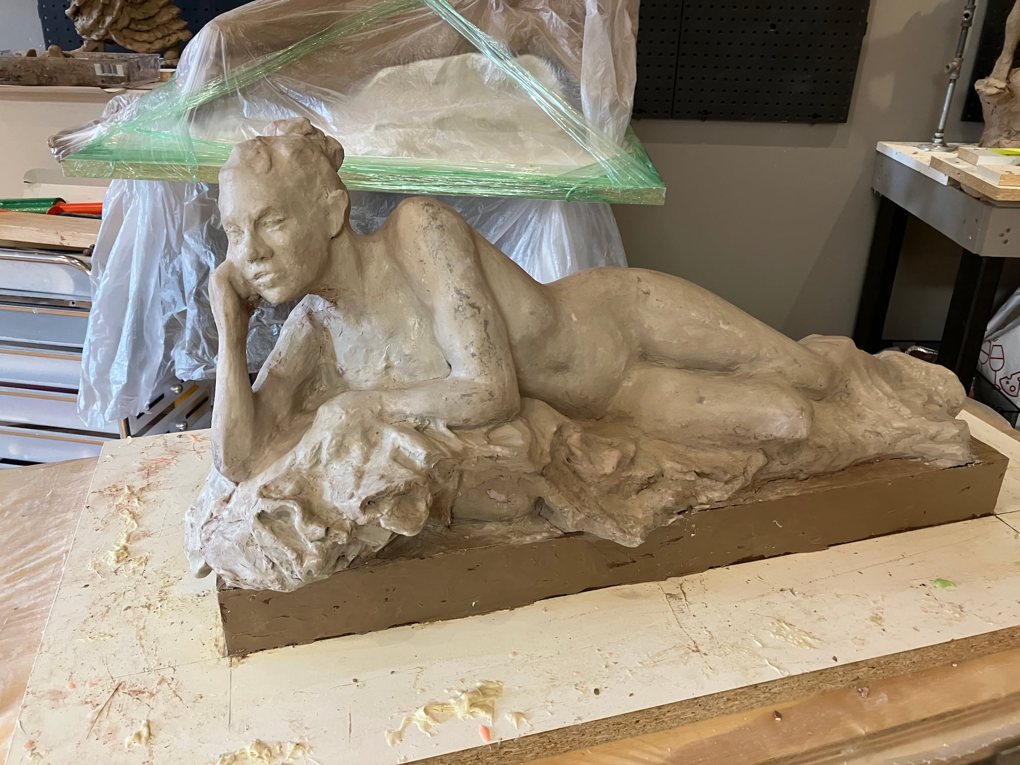 Clay sculpture of a reclining nude by Lois Rhomberg