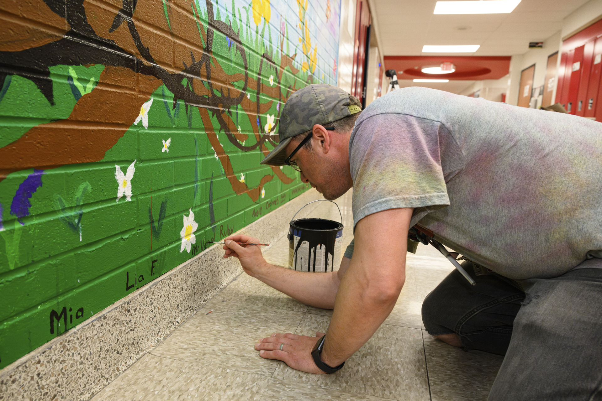 LIGHT Coordinator Scott Vensel paints his name onto a mural in his school.