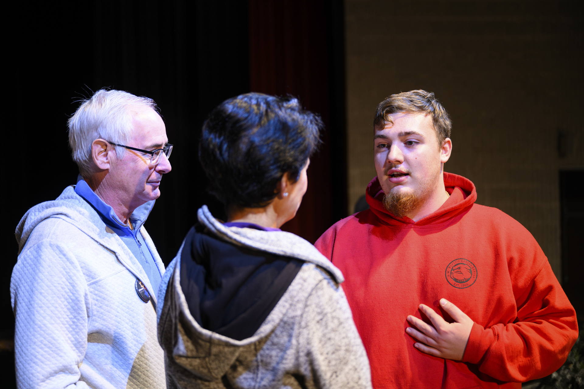 A student speaks with two 10.27 REACH Speakers.