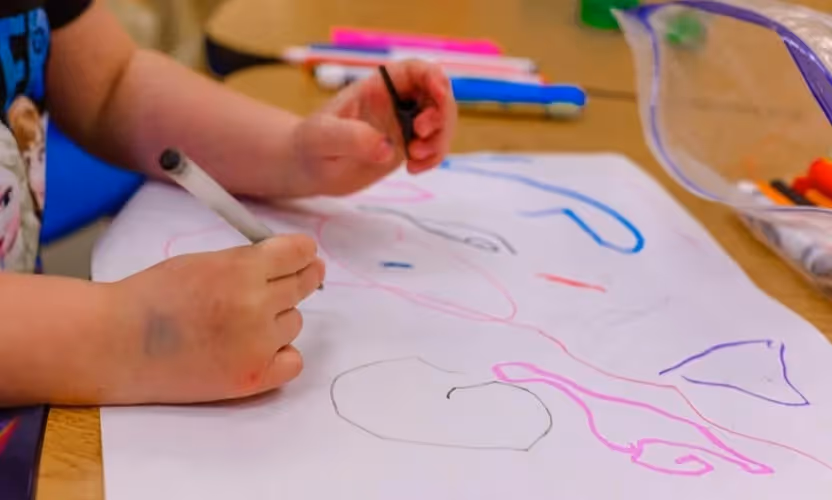 A child coloring on a piece of paper