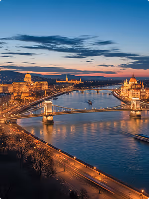 Evening view of Budapest with the illuminated Chain Bridge and Parliament along the Danube River.