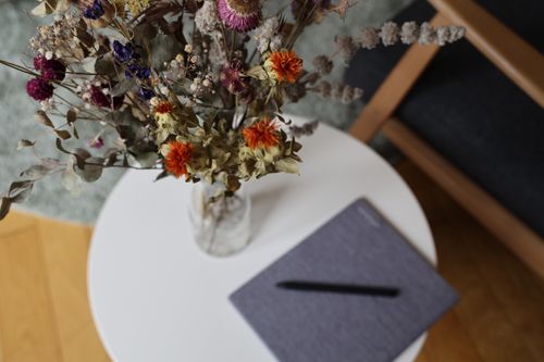 A vase on a side table and writing materials