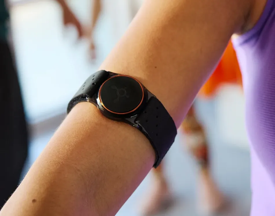 Woman wearing OTconnect Beat device in her arms.