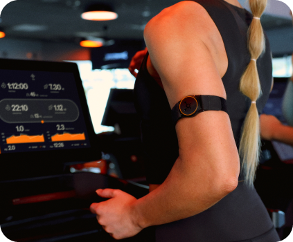 Person running on a treadmill wearing an OTconnect Beat.