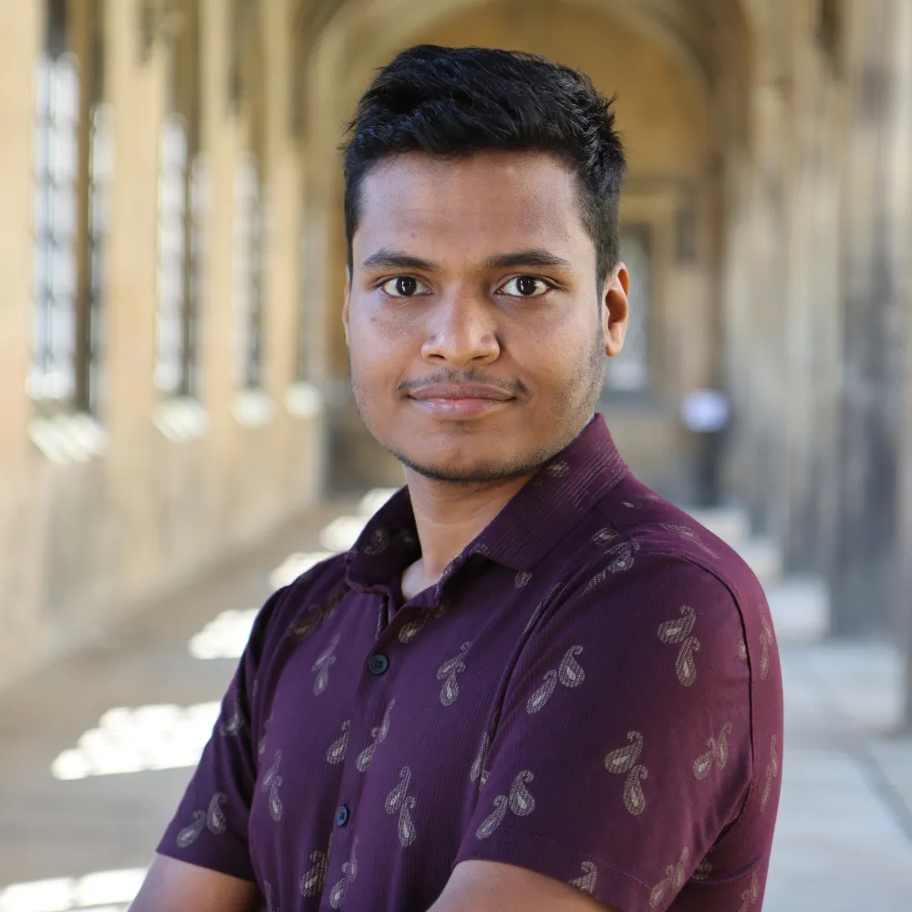 Pratyush Ghosh standing in the New Court Cloisters