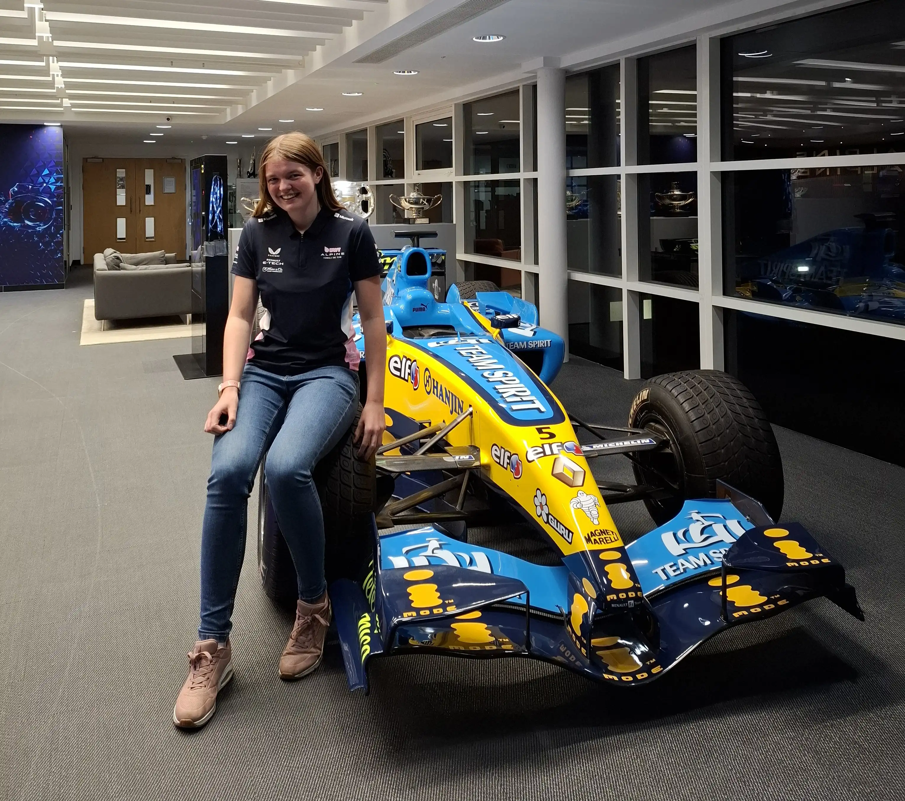 Rowan Saltmarsh sits on the tyre of a Formula One racing car 
