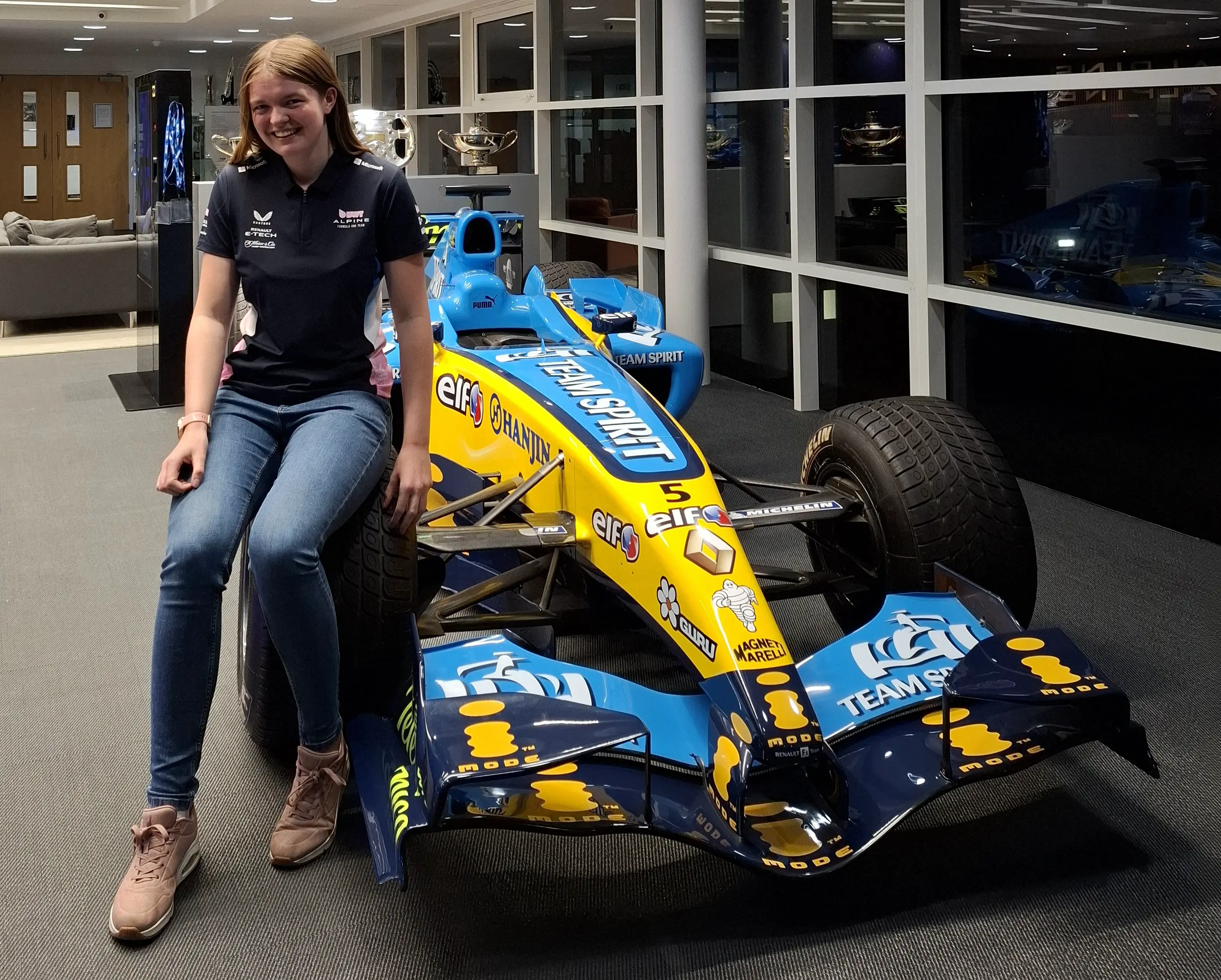 Rowan Saltmarsh sits on the tyre of a Formula One racing car 