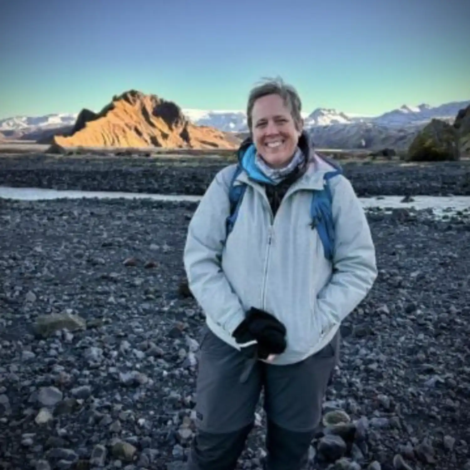 Professor Tamsin Mather stands in front of a volcanic panorama 