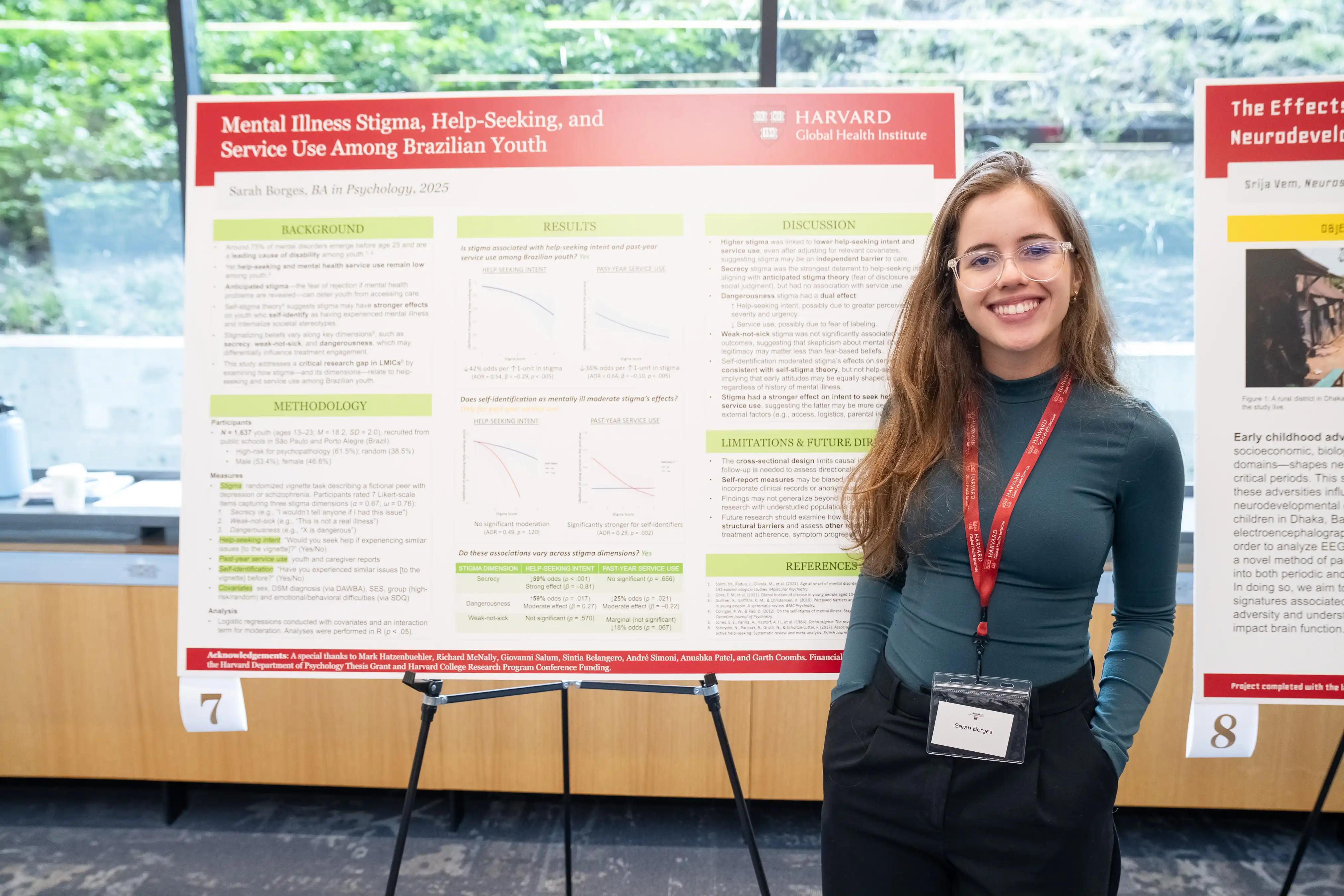 Sarah Aguiar Monteiro Borges stands in front of a research information board at Harvard at a symposium