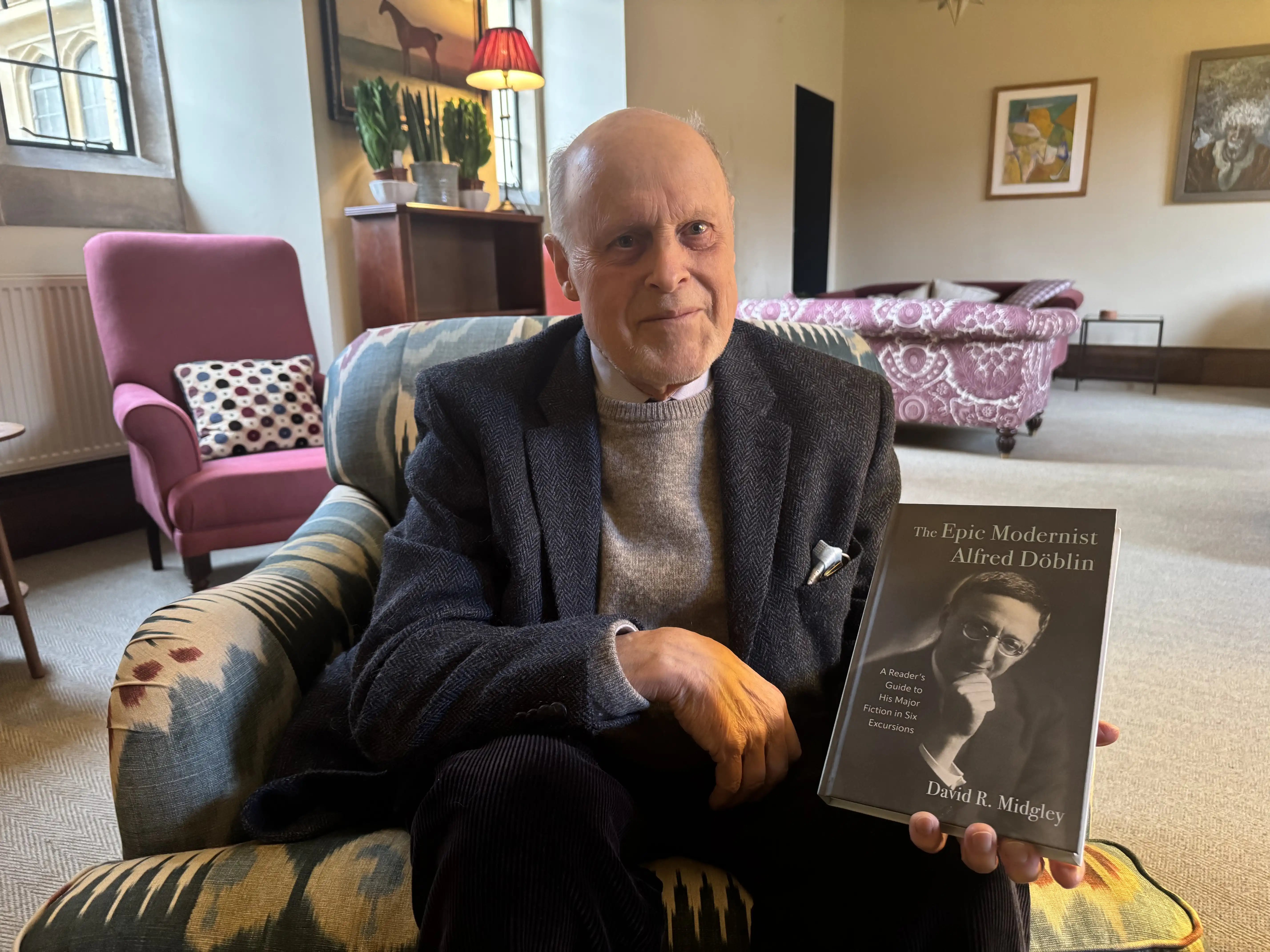 A photo of Professor David R Midgley in his office with his new book, The Epic Modernist: Alfred Döblin