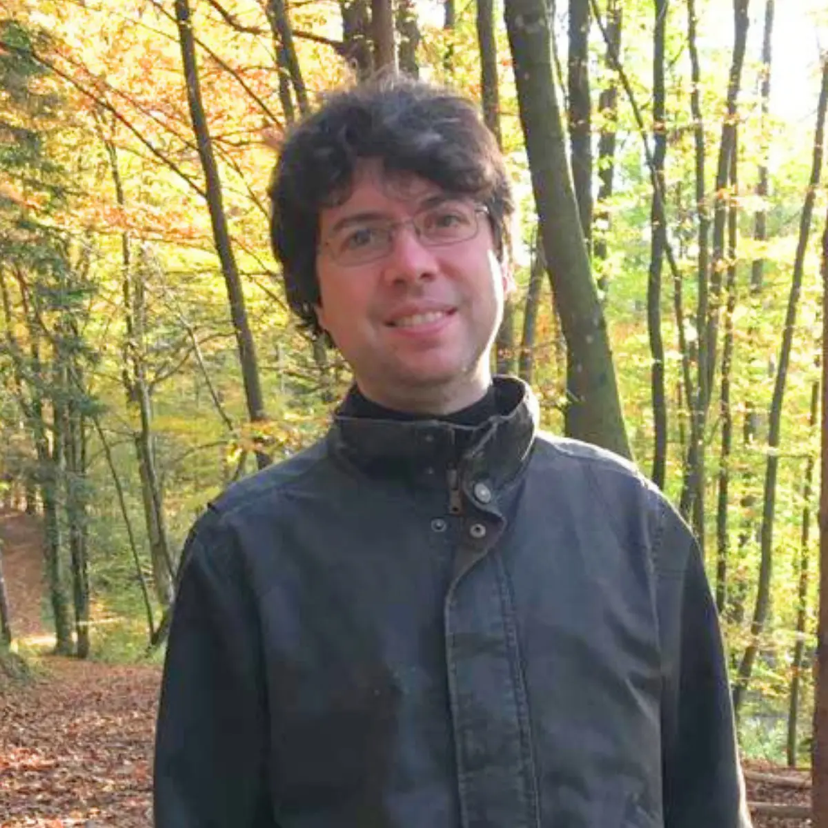 Nicola Morato walking in a forest looking at the camera