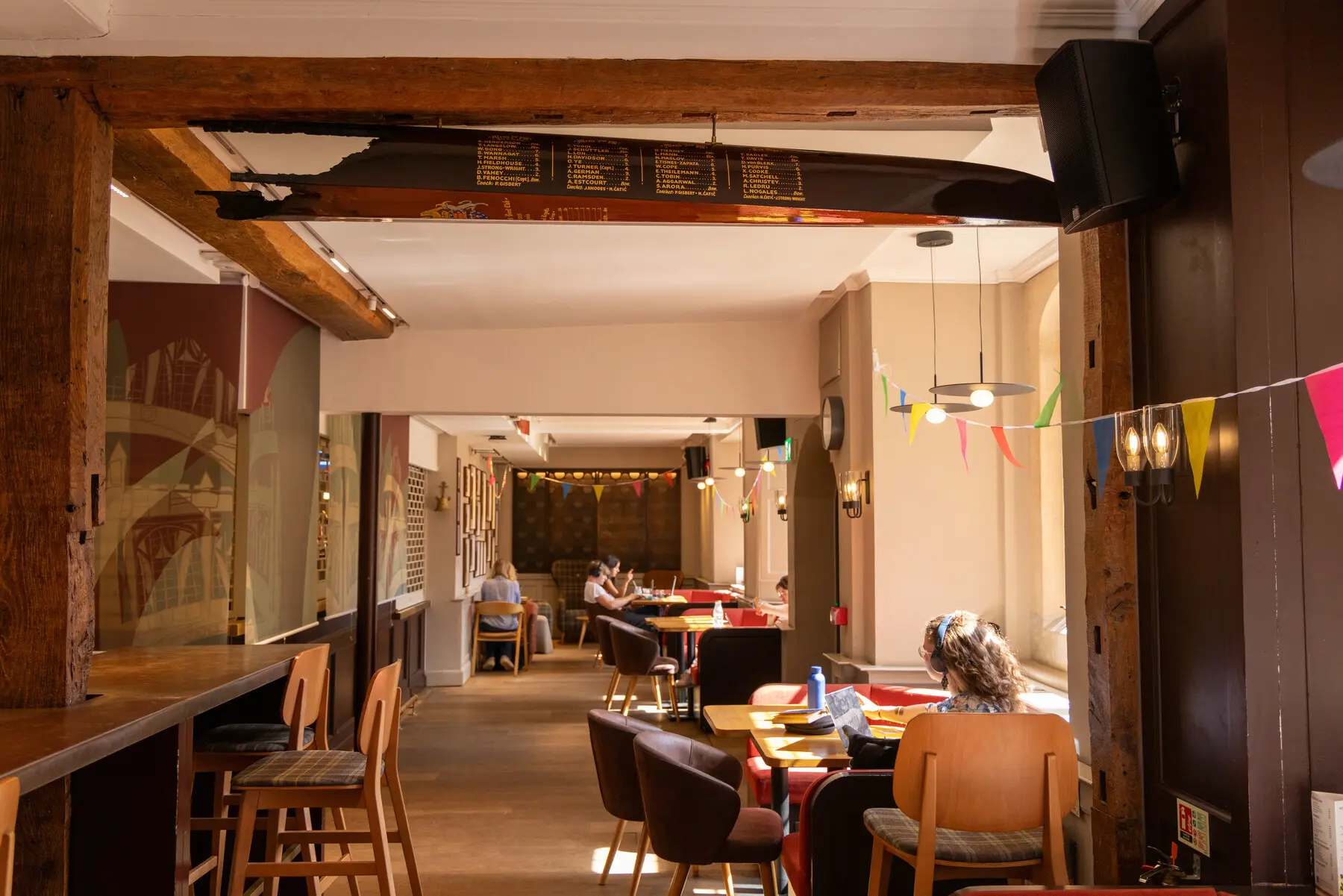 A charred bow of a rowing boat hangs from a beam in the College bar