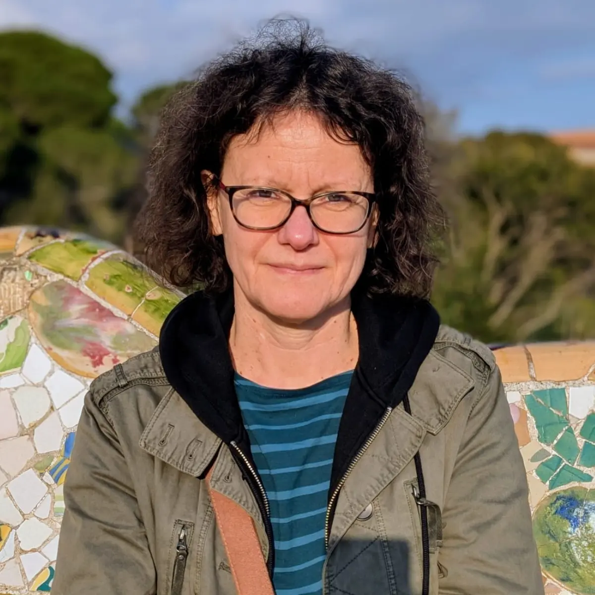 Professor Joanna Odrowąż-Sypniewska sits outside in front of mosaic patterned wall facing the camera.