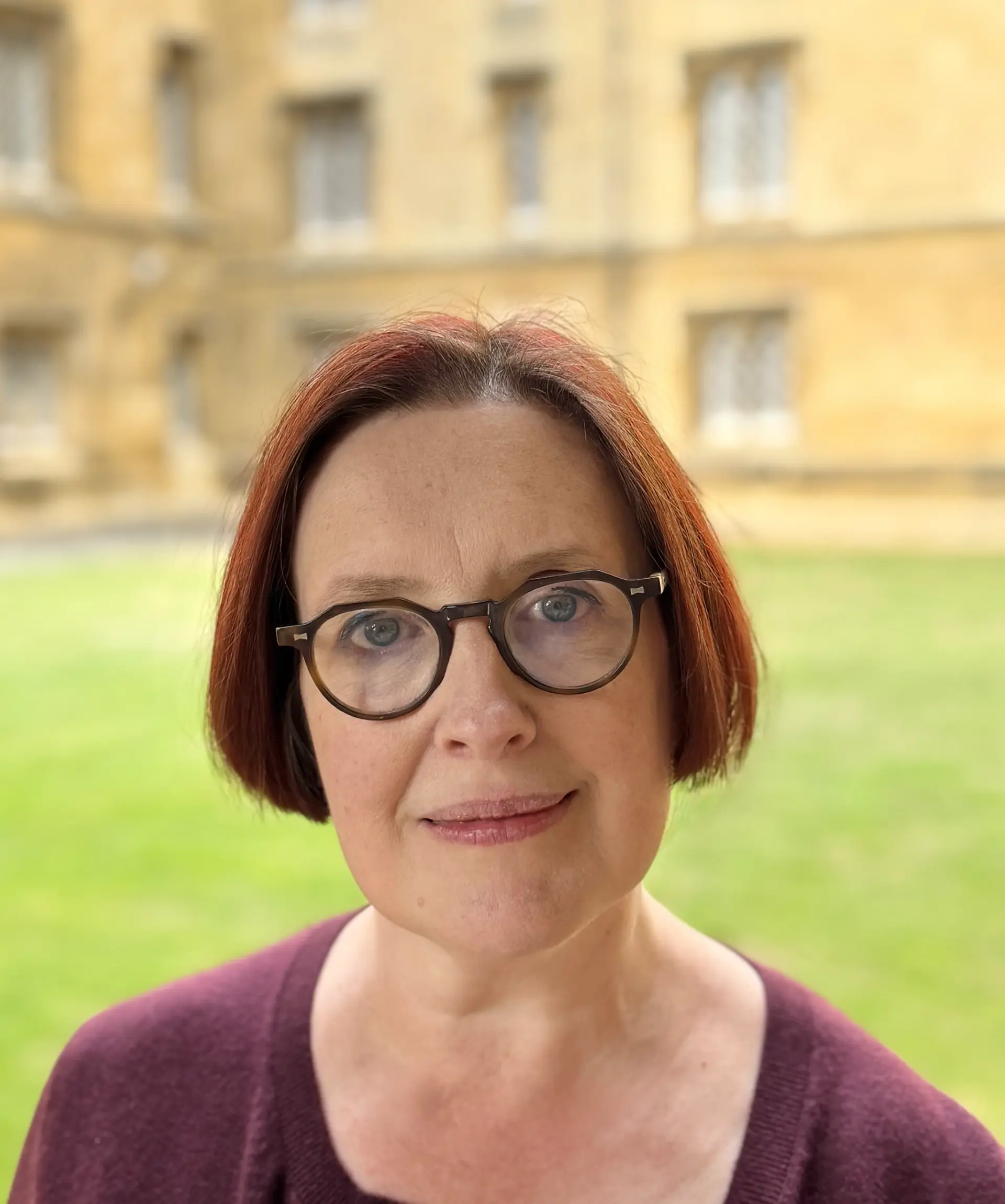 Dr Marie-Géraldine Lea looks at the camera with New Court in the background.