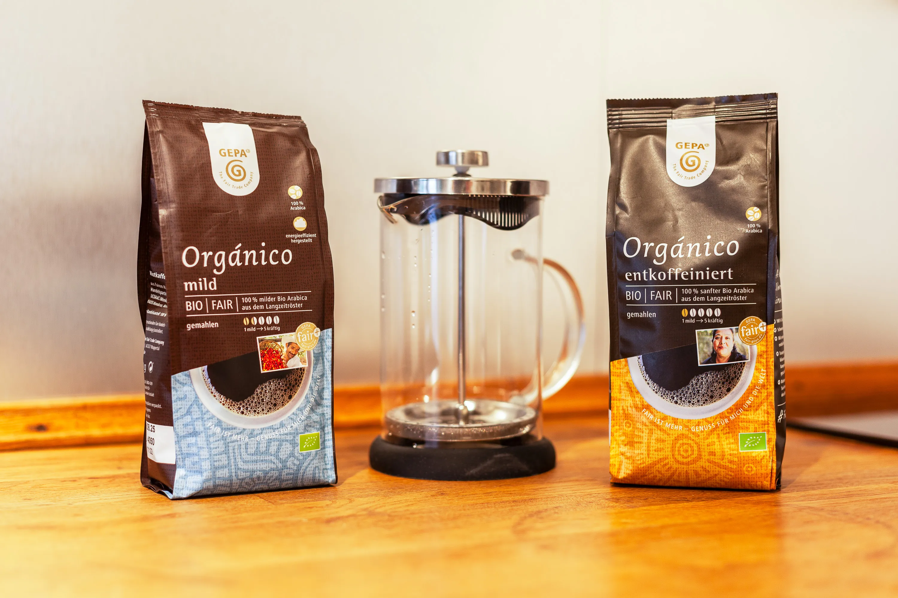 Zwei Packungen Fairtrade-Kaffee stehen auf der hölzernen Arbeitsplatte in der Küche in Hamburg-Winterhude. Ein Kaffee ist "mild" der andere "entkoffeiniert". Dazwischen steht eine Frenchpress.