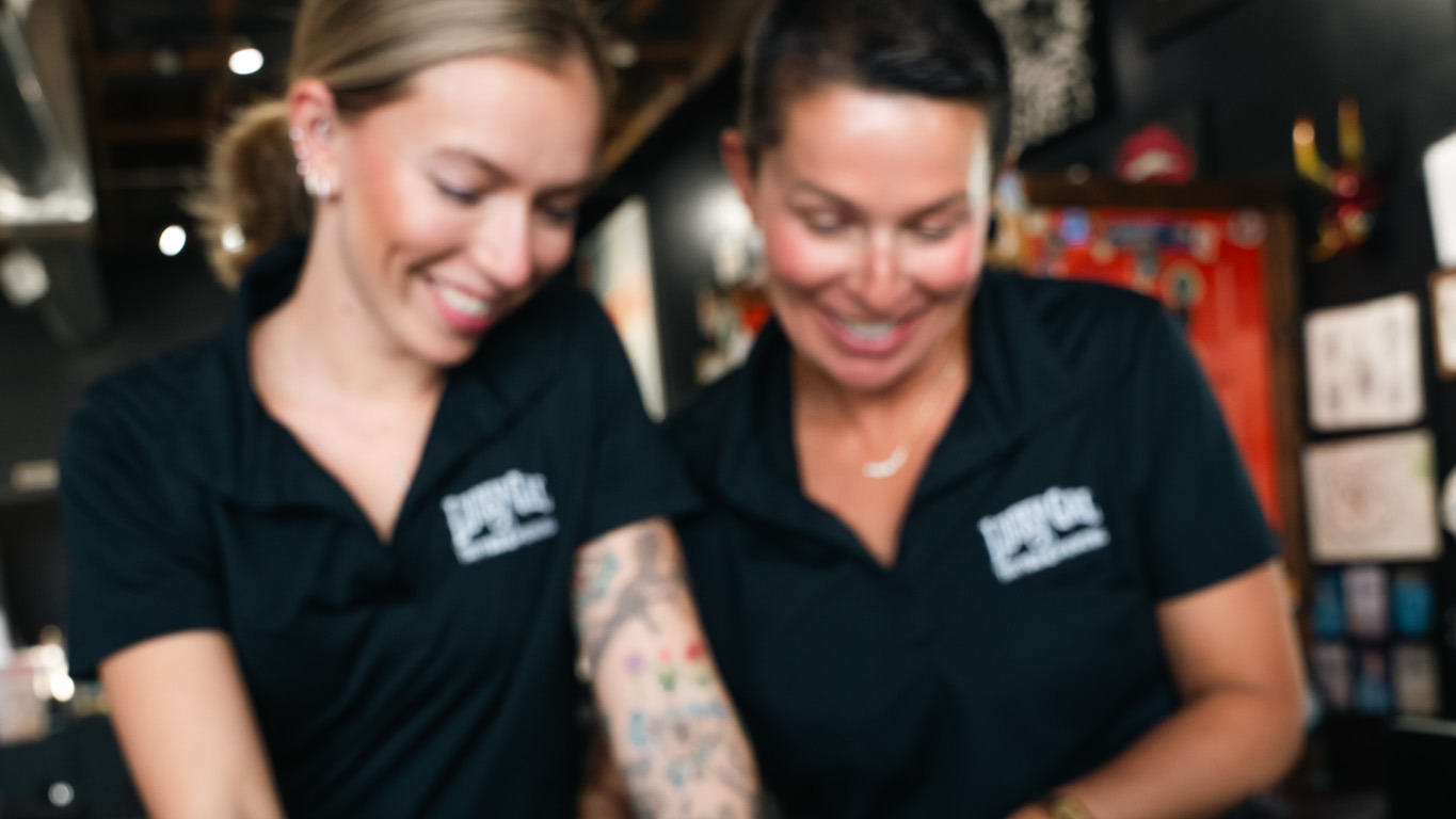 Two tattoo shop staff members using the Porter device at the front desk