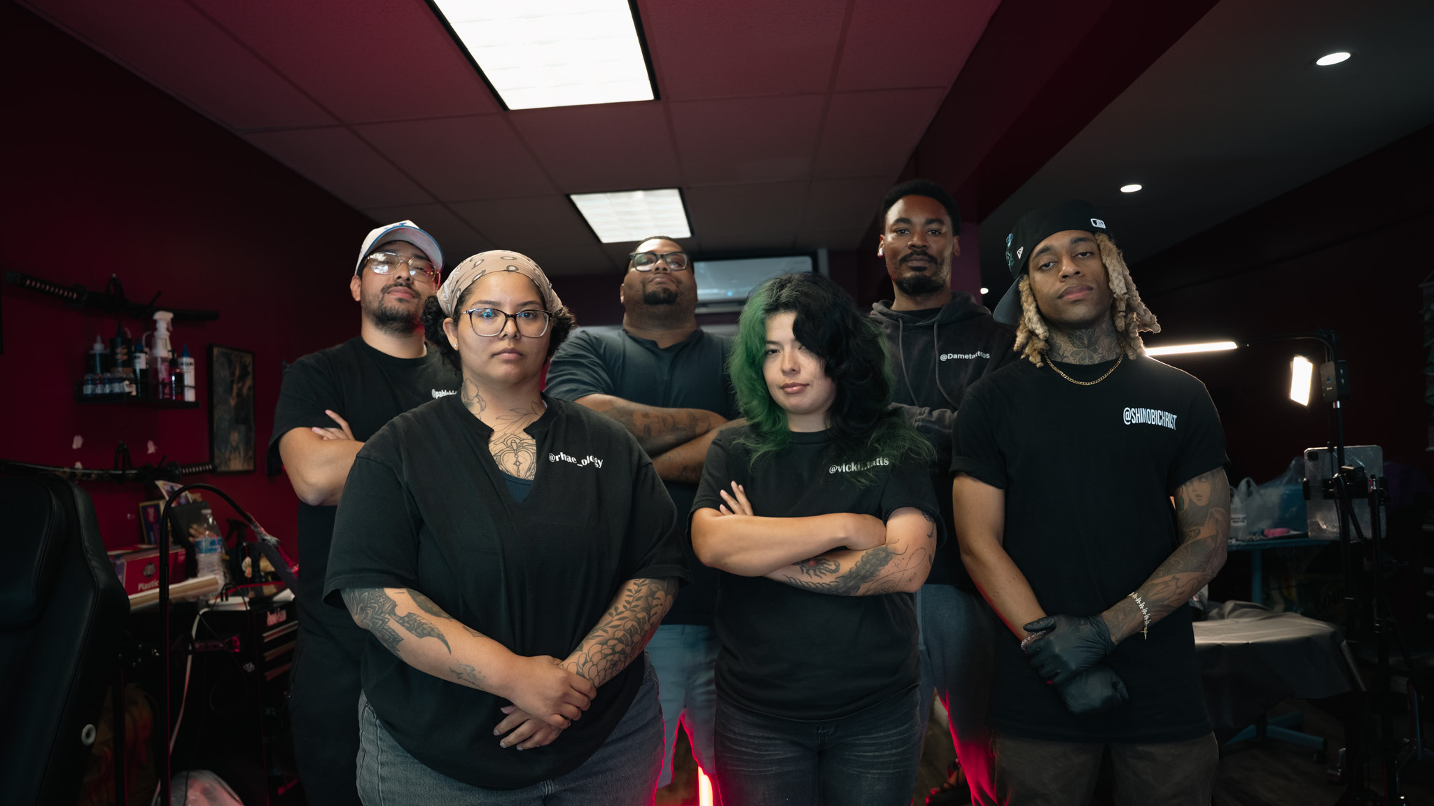 Tattoo shop team of artists posing together in their studio