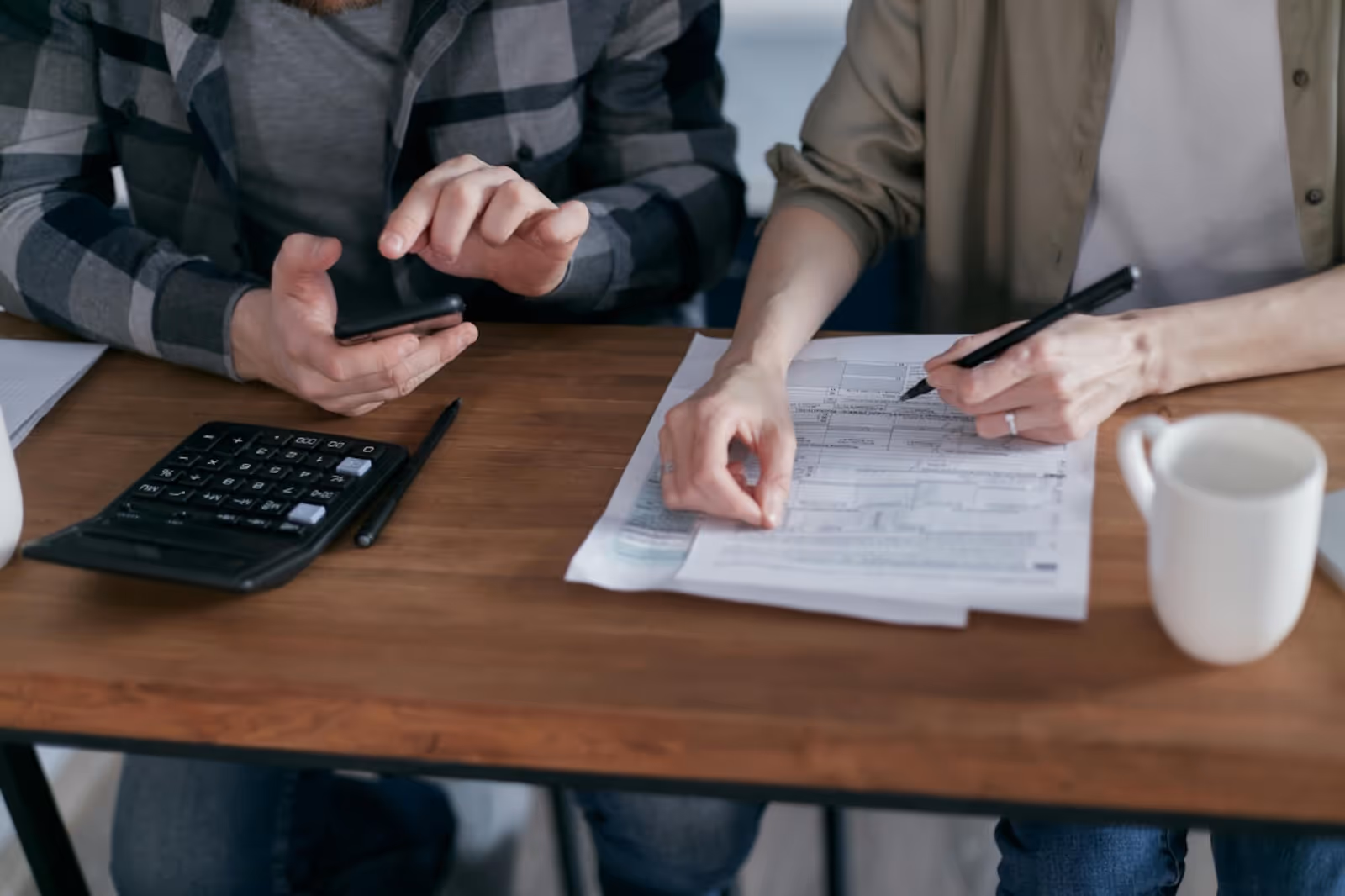 deux personnes font des calculs pour voir comment réduire leurs impôts en souscrivant au capital d'une PME