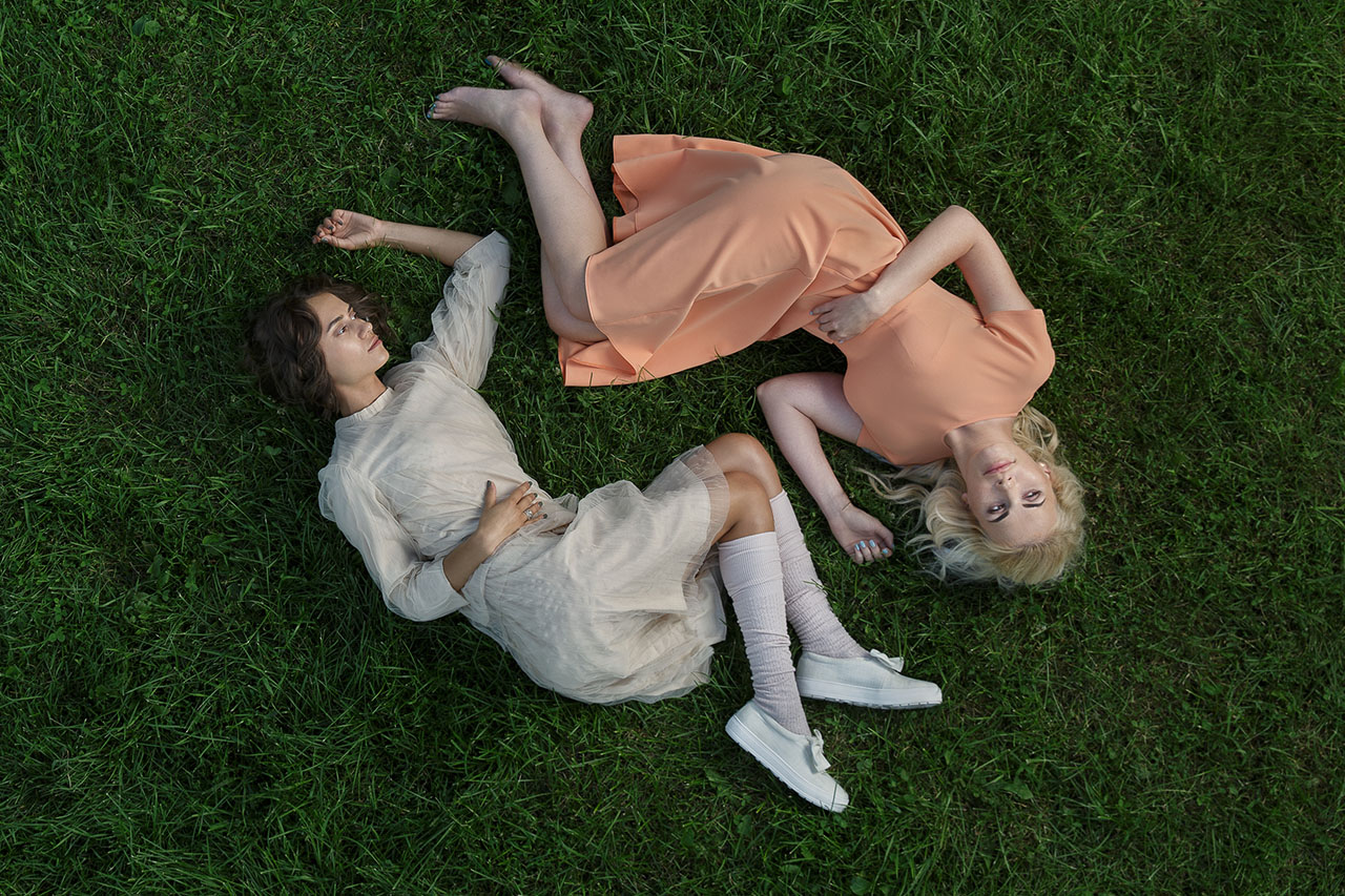 Midjourney prompt engineering for artistic re-imagination, featuring two models in dresses on grass, inspired by visual storytelling techniques.