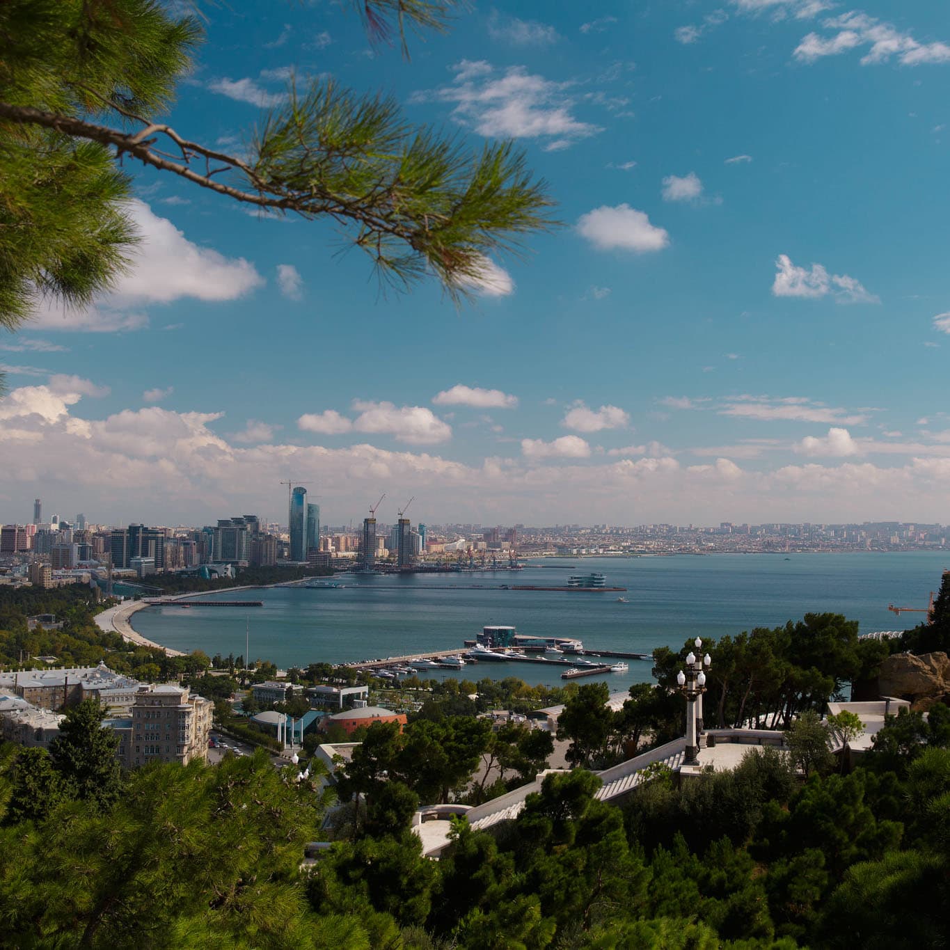 Baku skyline with waterfront, showcasing urban development and natural scenery. Midjourney prompt for cityscapes, photorealism, and detail accuracy.