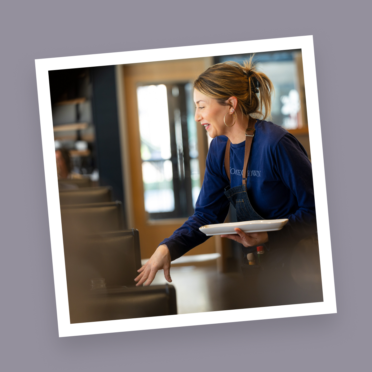 HomeGrown server smiling while setting a plate on a restaurant table