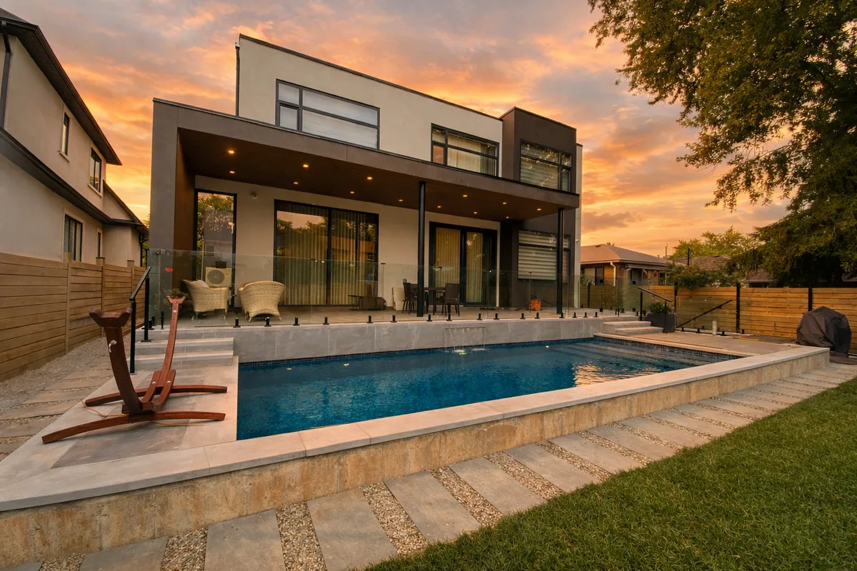 Full backyard overview of concrete pool with hardscape deck at sunset at Wildwood Drive