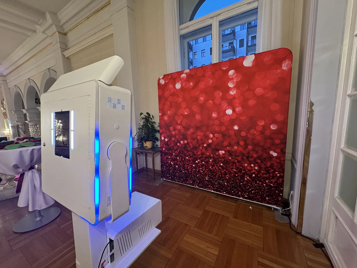 Fotobox Classic vor rotem Glitzer-Backdrop in historischem Saal