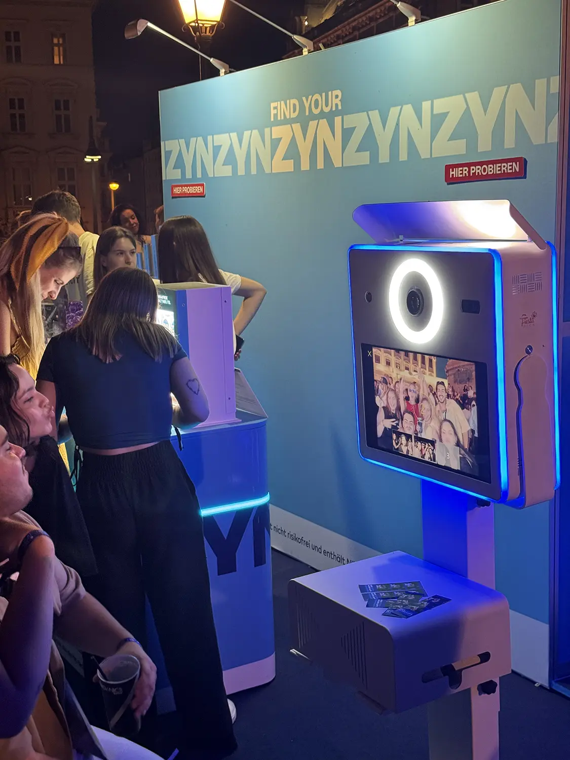 Gästegruppe betrachtet ihr Foto auf dem Screen der Fotobox Classic bei einem Markenevent
